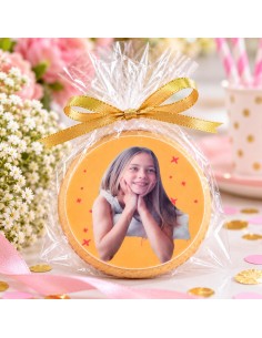 Round cookie with edible photo print of a smiling girl in gold ribbon bag